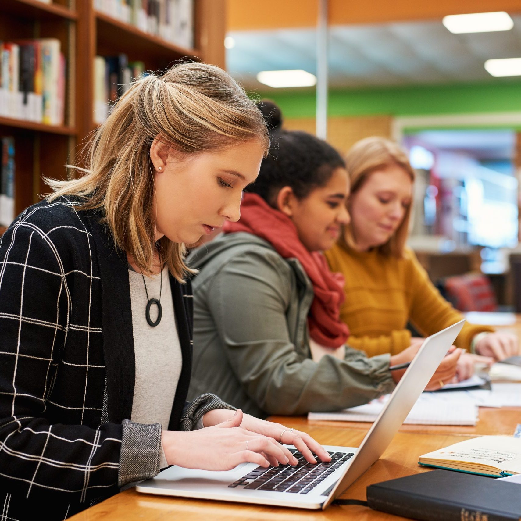 Laptop,,Typing,And,Woman,In,Library,For,Study,Group,With